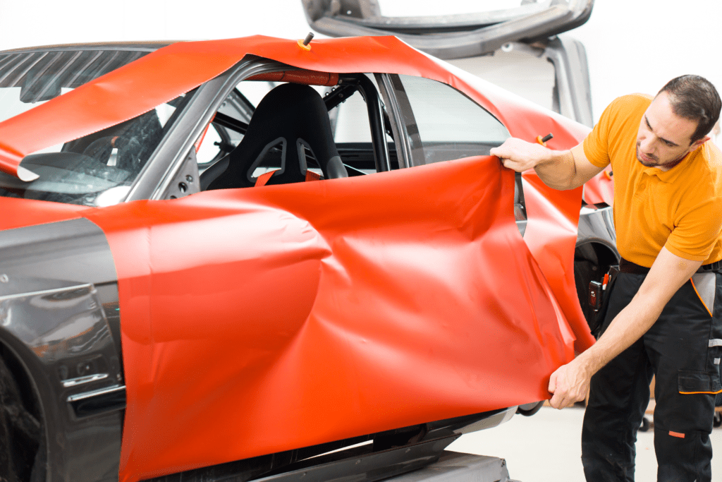 Black Car Being Wrapped in Red Vinyl
